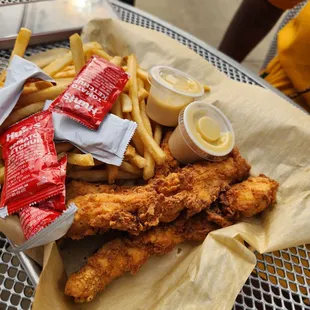 a basket of fried chicken and french fries