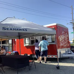 a red food truck with a white canopy