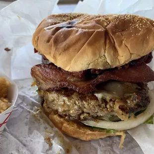 a hamburger with bacon, lettuce, and cheese