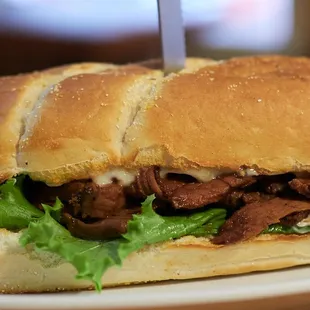 a beef sandwich with lettuce and cheese