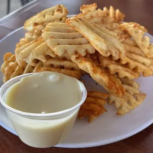 Sea Spuds aka waffles fries seasoned with old bay, cheese sauce on the side