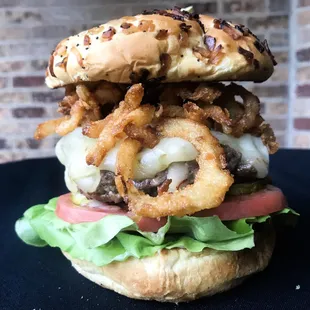 a hamburger with onion rings and lettuce