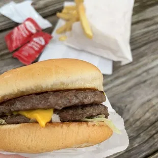 a hand holding a hamburger and fries