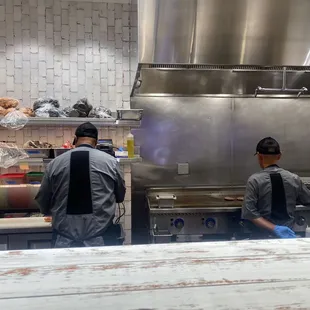 two men in a kitchen preparing food