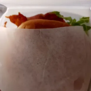 a hot dog in a bun with lettuce