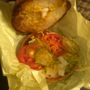 a person holding a sandwich in a wrapper