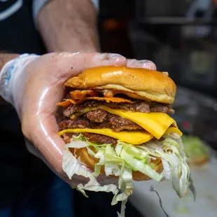 a person holding a large hamburger