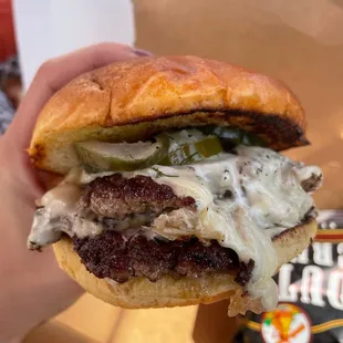 a hand holding a hamburger