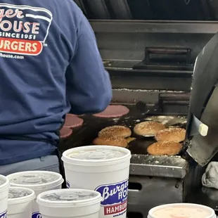 a man cooking burgers on a grill