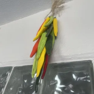 a bunch of chilis hanging on a wall