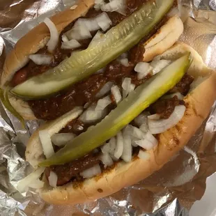 two hot dogs with onions and pickles