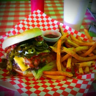 a burger and fries on a checkered tablecloth