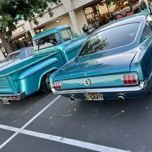 two classic cars parked in a parking lot