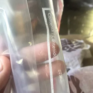 a hand holding a bag of food