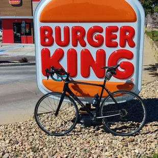 a bicycle parked in front of a burger king sign