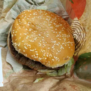a hamburger with sesame seeds and lettuce