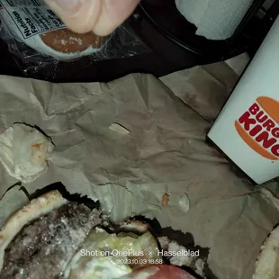 a hand picking up a half eaten hamburger