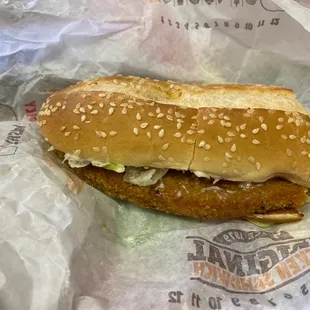 a chicken sandwich with lettuce and onions