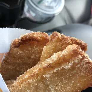 a hand holding a fried donut