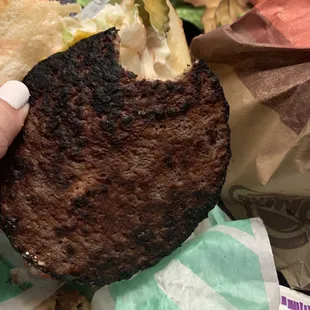 a hand holding a burger