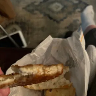 a hand holding a piece of bread