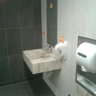 a bathroom with a sink and toilet paper dispenser