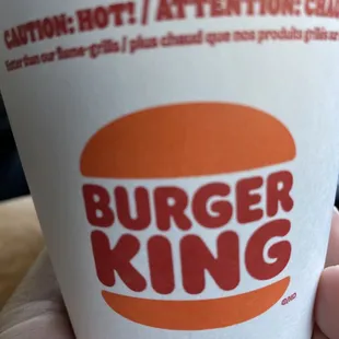 a hand holding a cup of coffee