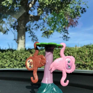 a pink flamingo and a monkey on top of a tree