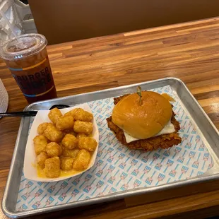 a plate of fried tater tots and a drink