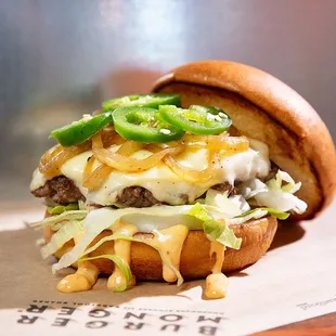 a hamburger with cheese and green peppers