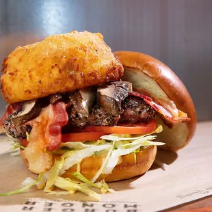 Crowd Favorite Burger topped with Tomato, Bacon, Portobello Mushrooms, and a Thick Cut Onion Ring