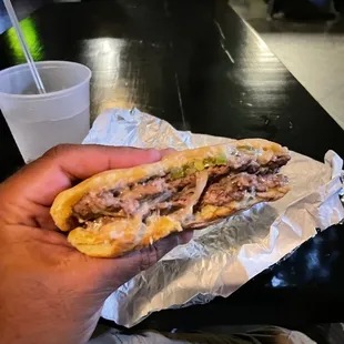 a hand holding a sandwich