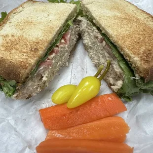 Tuna sandwich with a side of pickled carrots and banana peppers