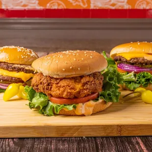 three burgers on a cutting board