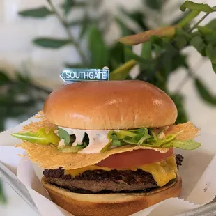 a hand holding a hamburger with a sticker on it