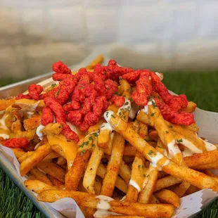 a tray of fries with sauce on top