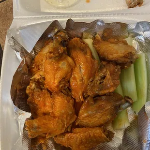 chicken wings and celery in a styrofoam container