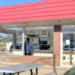 a man standing in front of a restaurant