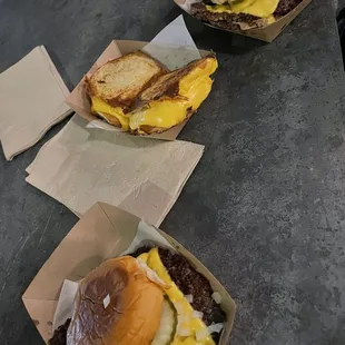 three cheeseburgers on a table