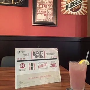 a menu and a drink on a table