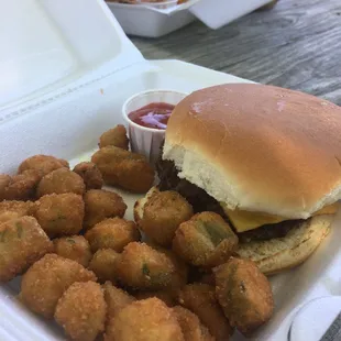 a burger and tater tots in a styrofoam container