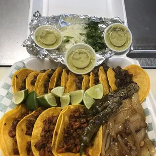 a tray of tacos and salsa