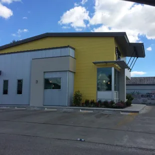 a yellow building with a blue sky in the background