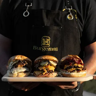 a man holding a tray of hamburgers