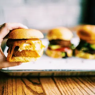 a person holding a sandwich on a tray