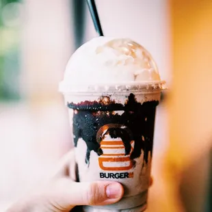 a hand holding a cup of ice cream