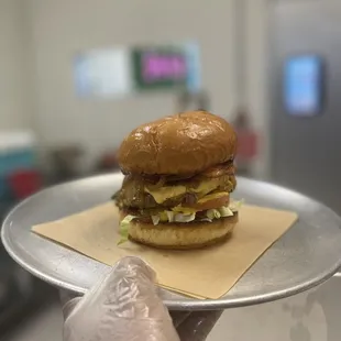 a person holding a tray with a hamburger on it