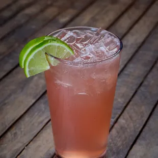 a pink drink with a lime wedge