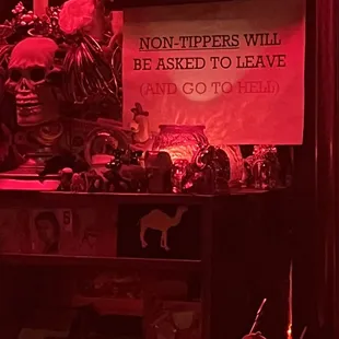 a sign on a shelf in a bar