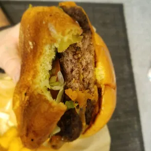 a hand holding a hamburger